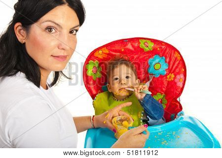 Mother Giving Food To Messy Baby
