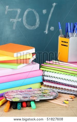 Office supplies on table on school board background 