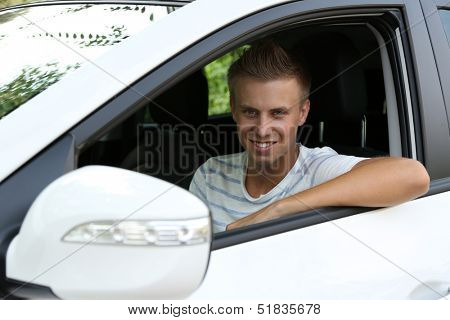 Young man in his new car