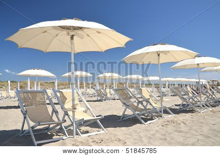 Beach umbrellas and chairs on beautiful beach Marina di Vecchiano nearby Pisa, Tuscany in Italy
