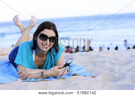 woman lying on the beach with your cell phone