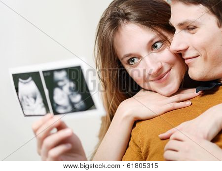 Beautiful Couple Watching With Emotion Ultrasound Pictures Of Their Baby