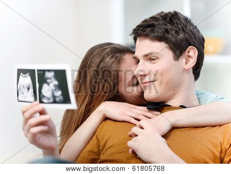 Beautiful Couple Watching With Emotion Ultrasound Pictures Of Their Baby