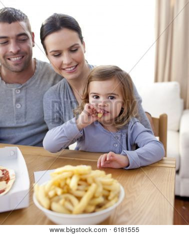 kleines Mädchen essen frites und Pizza zu Hause