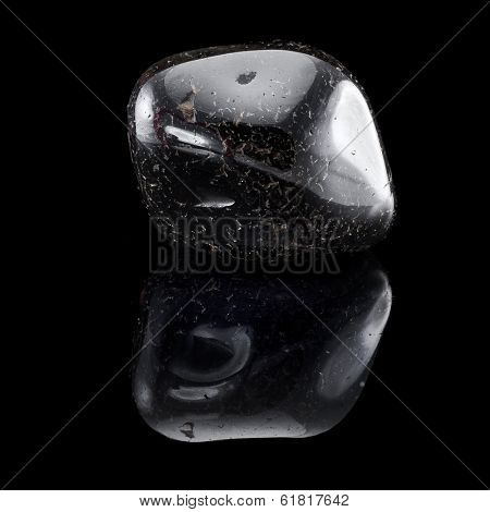 Black Oniks stone close up with reflection on black surface background