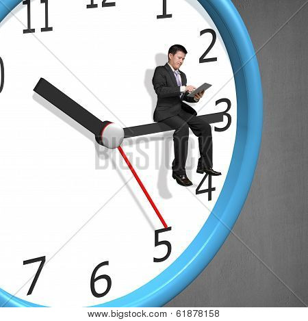 Businessman Sitting On Clock Pointer