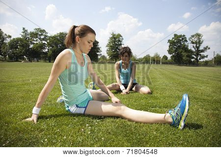 Two Young Girls Stetching Before A Jogging