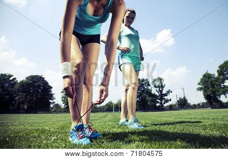 Two Young Girls Stetching Before A Jogging