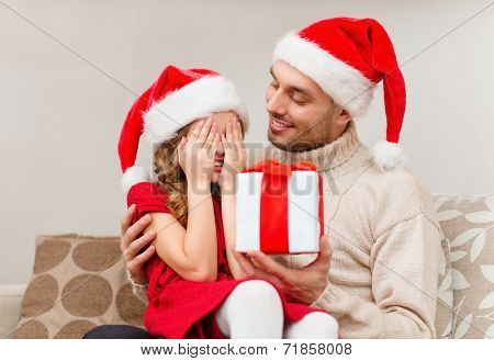 family, christmas, x-mas, happiness and people concept - smiling daughter with closed eyes waiting for a present from fathe