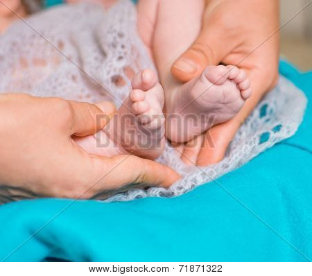 newborn baby feet on female hands