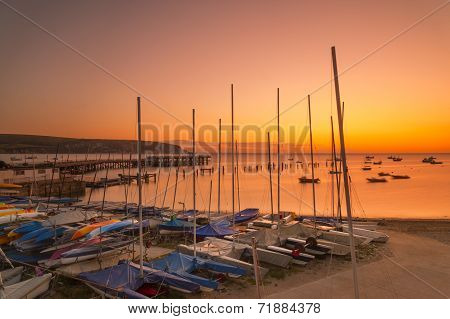 Boats the new and old piers are illuminated by the orange pre-dawn