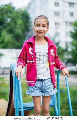 Cute little girl is playing in playground, outdoor shoot