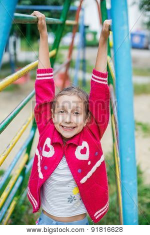 Cute little girl is playing in playground, outdoor shoot