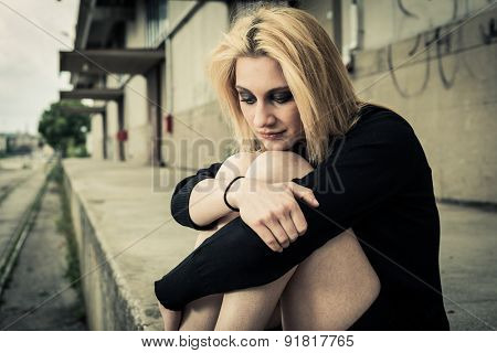 Sad girl alone in urban blight