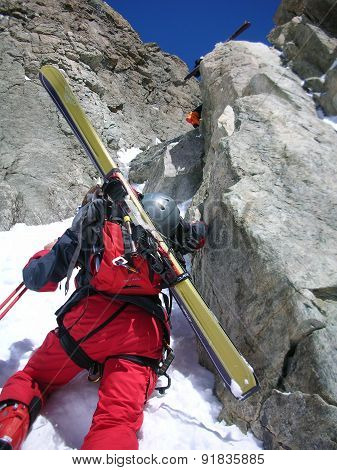 Tour skier climbing a rock