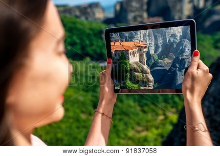 Woman photographing Meteora monastery in Greece