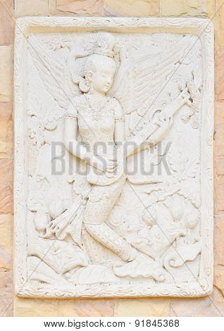 Statue Of A Woman Playing Fiddle . Thai Ancient Stone Carving
