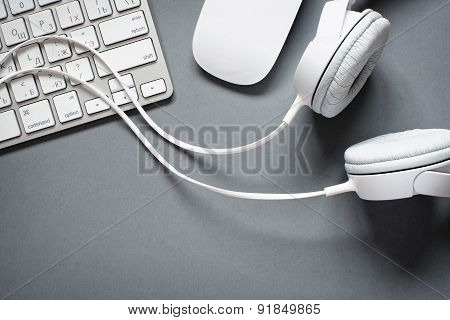 White Headphones, Keyboard And Mouse On Grey Desk