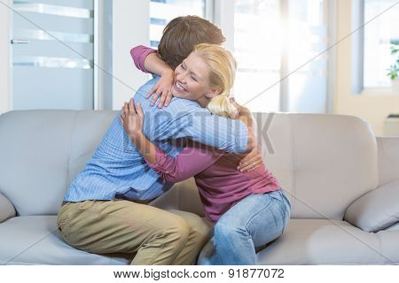 Reconciled couple hugging in the therapist office