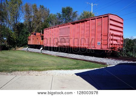 PLAINFIELD, ILLINOIS / UNITED STATES - SEPTEMBER 20, 2015: An old boxcar and caboose of the former Elgin, Joliet and Eastern (EJ&E) Railway sits on a railroad track in Plainfield.