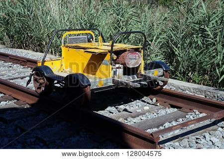 PLAINFIELD, ILLINOIS / UNITED STATES - SEPTEMBER 20, 2015: An antique yellow drasine sits on a track outside the old Plainfield Depot, which now serves as a museum operated by the Plainfield Historic Preservation Commission.