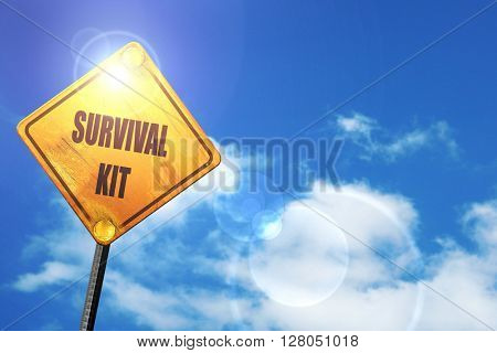 Yellow road sign with a blue sky and white clouds: Survival kit 