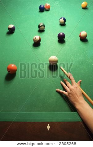 Mão de mulher se preparando para bater bola piscina ao jogar bilhar.