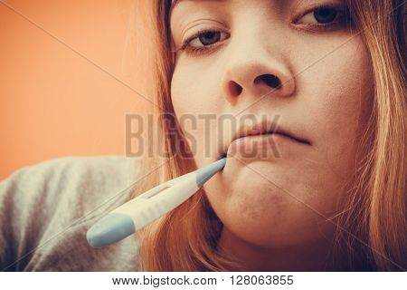 Sick ill woman with digital thermometer in mouth. Young girl having high fever measuring temperature. Health. Instagram filter.