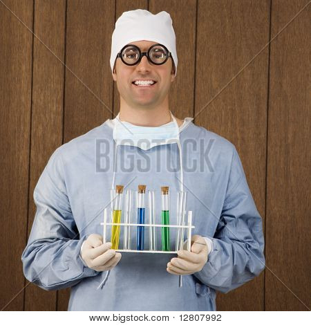 Mid-Adult cirujano caucásico de hombre con gafas gruesas y sosteniendo el tubo de ensayo de bandeja.