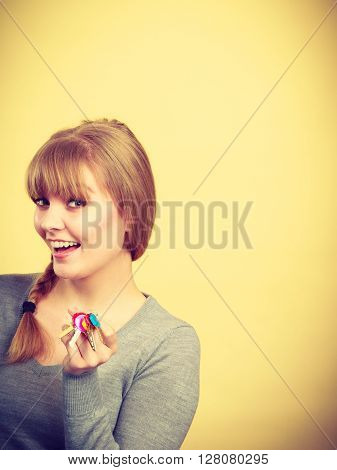Ownership and property concept. Young blonde smiling female owner with bunch of colorful keys. Woman with key antry to her first own flat.