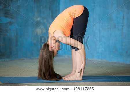 Sporty Beautiful Young Woman Doing Uttanasana Pose