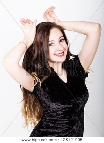 Portrait of a funny casual woman showing rabbit geture over his head. different happy emotions..
