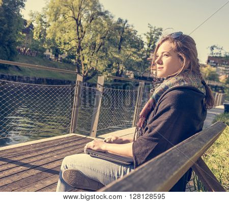 Young and attractive woman meditating with closed laptop. Feeling free.