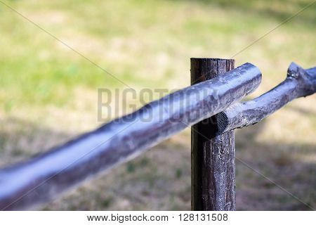 fragment of an old column and poles from a wooden fence for the ranch closeup on an indistinct background