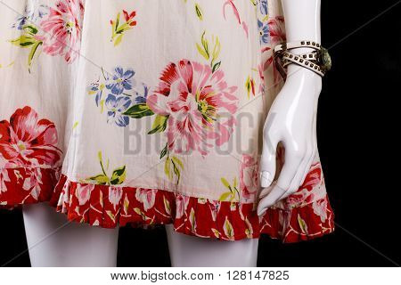 Floral sarafan and white watch. Tiny watch on female mannequin. Woman's new accessory on display. Last item in stock.