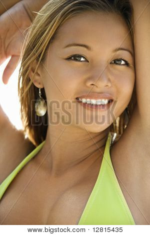 Jóvenes asiática filipina hembra adulta en traje de baño mirando visor sonriendo.