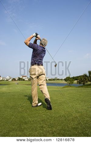 Rückansicht des Lüneburg adults Golfschläger schwingt.