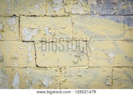 texture of old building wall with yellow, peelling off paint