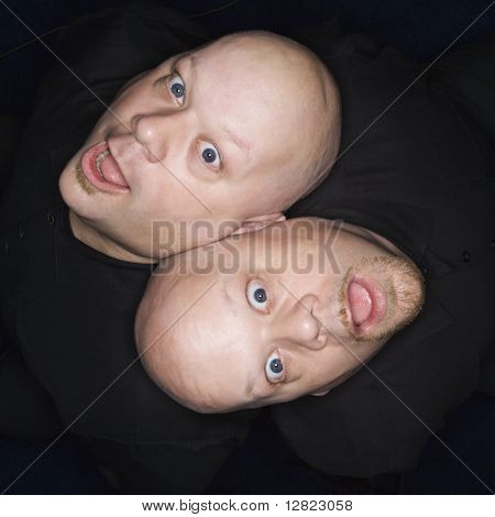 Jimmy vue des hommes de jumeau chauve caucasienne assis dos à dos faisant des expressions faciales.