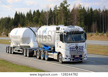 SALO, FINLAND - APRIL 29, 2016: White Mercedes-Benz Arocs 3258L tank truck of Kuljetus Auvinen hauls cement on motorway in South of Finland. Kuljetus Auvinen is a leading builder of super show trucks.