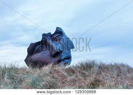 Scheveningen Netherlands - April 21 2016: sculpture of Igor Mitoraj in the dunes of Scheveningen. Mitoraj is a famous sculptor. His works are distributed in several European cities