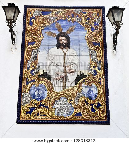 CORDOBA, SPAIN - September 11, 2015: An azulejo (tiles) ceramic panel depicting Jesus Christ on a wall in the Compas de San Francisco Cordoba on September 11, 2015 in Cordoba, Spain