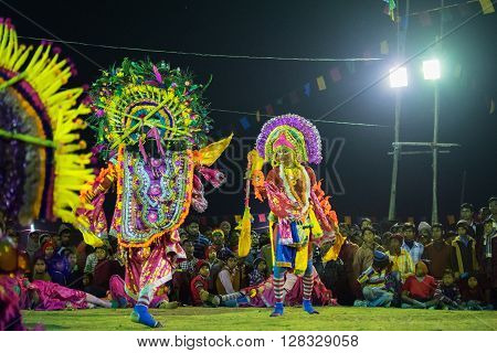 BAMNIA PURULIA WEST BENGAL INDIA - DECEMBER 23RD 2015 : Masked Dancers performing at Chhau Dance festival at night. Shot under colored light. It is a popular local Indian tribal martial dance based on Hindu myth.