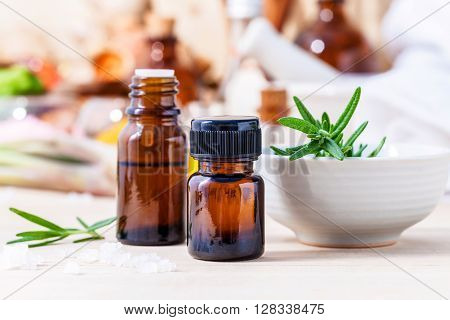 Fresh Rosemary And Essential Oil With Shallow Depth Of Field Setup On Wooden Background .