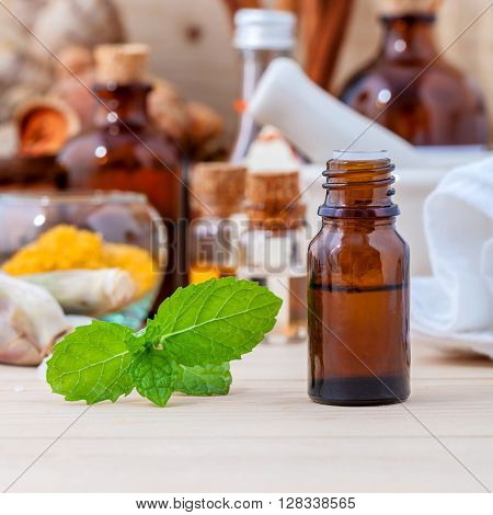Fresh Green Mint And Essential Oil With Shallow Depth Of Field Setup On Wooden Background .