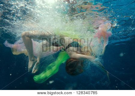 Underwater girl around the air bubbles it dives.