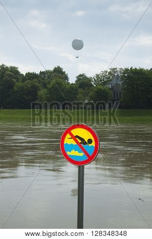 Poland Kraków flooded Vistula/Wisła river embankments no swimming sign over the water sightseeing baloon in the background