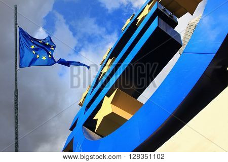 FRANKFURKT, GERMANY - DEC 17, 2011: Euro sign at European Central Bank headquarters in Frankfurt Germany 17 December 2011 with dark dramatic clouds symbolizing a financial crisis