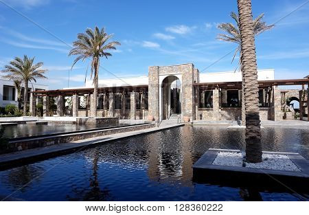 HERAKLION, CRETE, GREECE - MAY 13, 2014: The big blue swimming-pool with palms and beach in luxury class hotel Grecotel Amirandes, May 13, 2014, Greece.