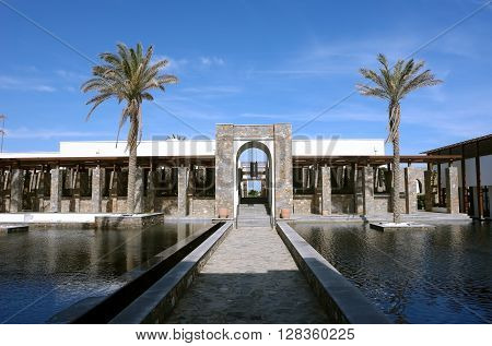 HERAKLION, CRETE, GREECE - MAY 13, 2014: The big blue swimming-pool with palms and beach in luxury class hotel Grecotel Amirandes, May 13, 2014, Greece.